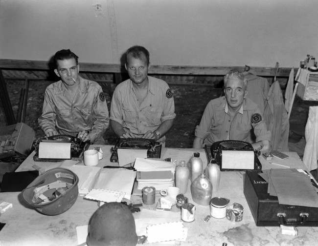 Three war correspondents work in the press hut on Guadalcanal. 1943