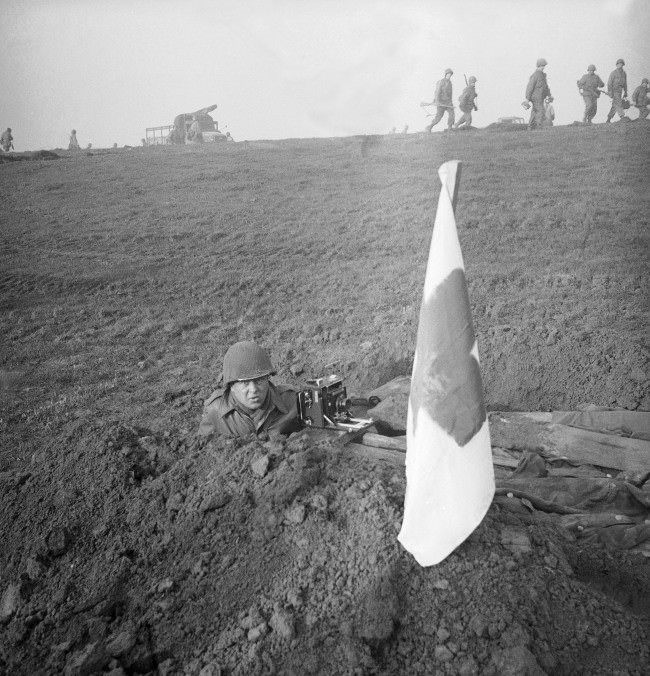 Henry Griffin, Associated Press war photographer takes cover in a fox hole on the banks of the Rhine. 1945