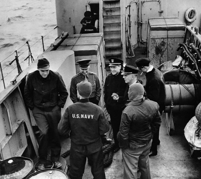 A group of press correspondents chat on board a USS Landing Craft Infantry enroute to amphibious maneuvers somewhere off the coast of England. 1944