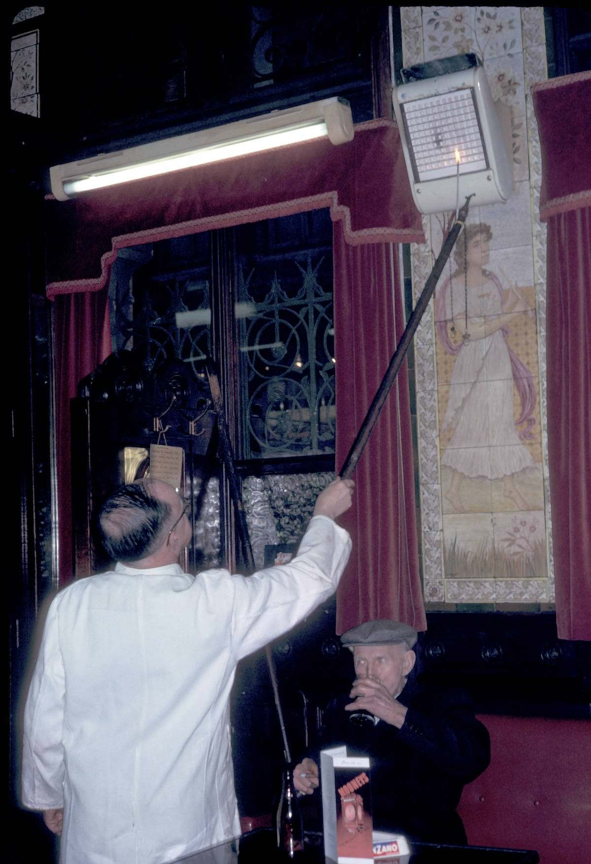 Man adjusting gas heater at Bruxelles Bar 1964