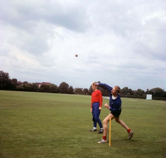 England’s Jack Charlton bowls watched by George Eastham at Roehampton, 1966.