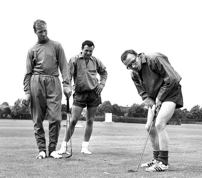 Nobby Stiles, the Manchester United wing-half, concentrates hard during a putting session at the Bank of England Sports Club ground, Roehampton, London, where he was training with other members of England’s World Cup squad. Watching him are Leeds United half-back Jackie Charlton (left) and Blackpool full-back Jimmy Armfield, 1966.