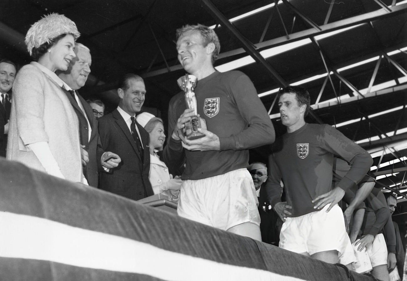 Queen Elizabeth II smiles after presenting England captain Bobby Moore with the Jules Rimet trophy, 1966.