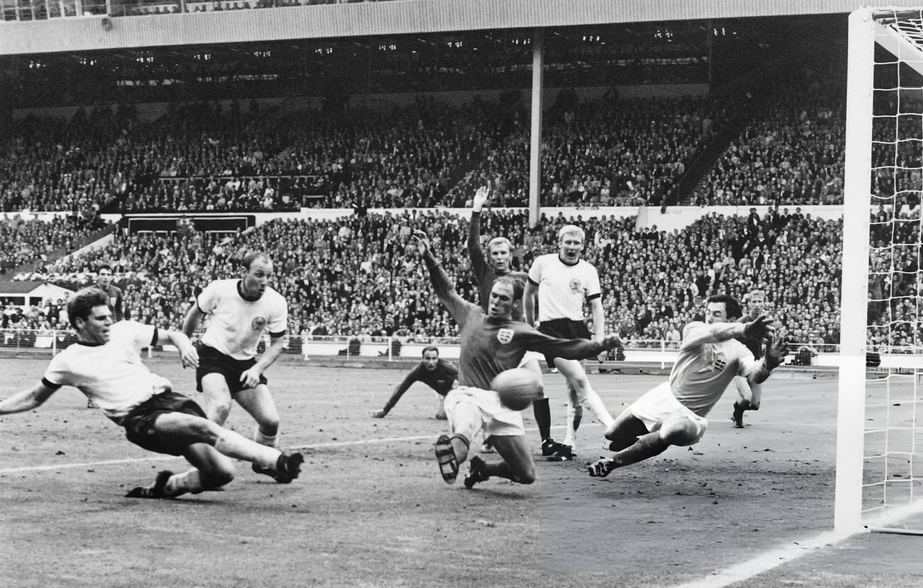 German defender Wolgang Weber ties the score at 2 on a last minute shot past English defender Norbert Stiles, 1966.