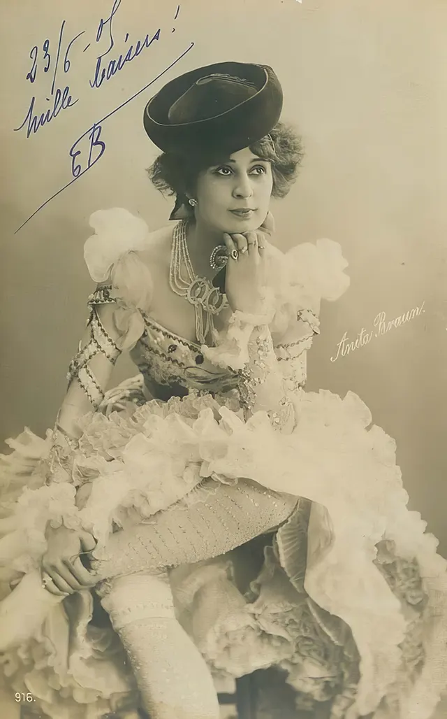 A costumed girl poses in a cap, circa 1910.