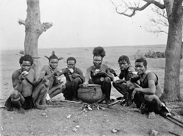 Zulu men near a cauldron, 1920-1930.