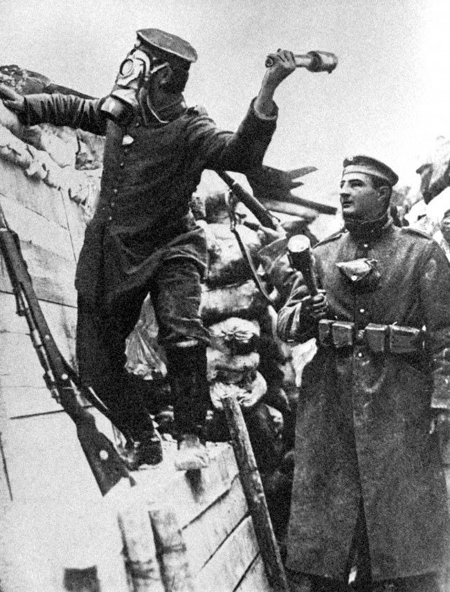 German soldiers wearing gas masks and throwing hand grenades.