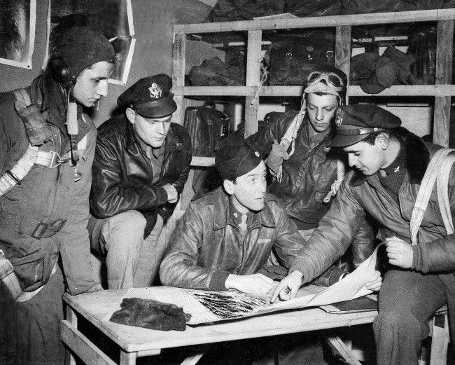 Major Jimmy Stewart talks over the final details of a mission with flyers about to take off, from left to right: Sgt. Keith M. Dibble of Rixford, Pa.; first Lt. Roger Counselman of Meadville, Pa.; Stewart; Sgt. Joseph T. Fiorentino of Philadelphia, Pa.; and second Lt. A.E. Lensky of Monessen, Pa., April 19, 1944, in England during World War II.