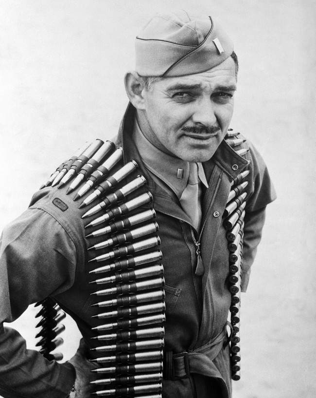 First Lieut. Clark Gable, former movie actor now an aerial gunner in the Army Air Forces, wears a double shoulder sling of .50 caliber machine gun bullets in taking off on a practice firing mission at Tyndall Field in Panama City, Florida on Jan. 20, 1943.