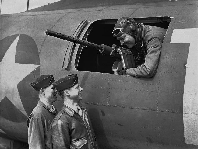 American film star Clark Gable at the waist gun position of his Flying Fortress, on an airfield somewhere in England on June 5, 1943, talking to Sergeant Gunner Kenneth Huls, left, and Sergeant Gunner Phillip Hulse.