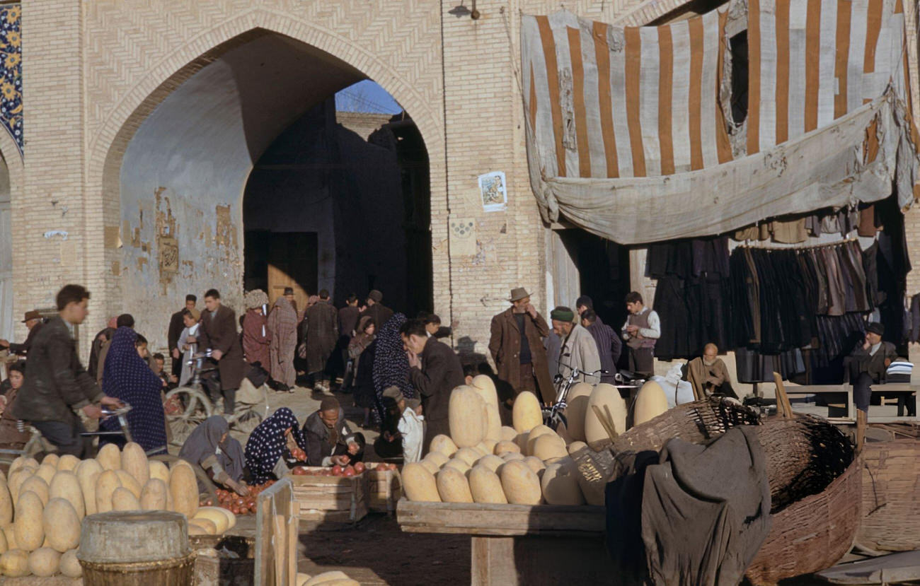 Pedestrians passing customers being served by market traders on a street in the bazaar district of Isfahan, in the Isfahan Province of Iran, circa 1960.