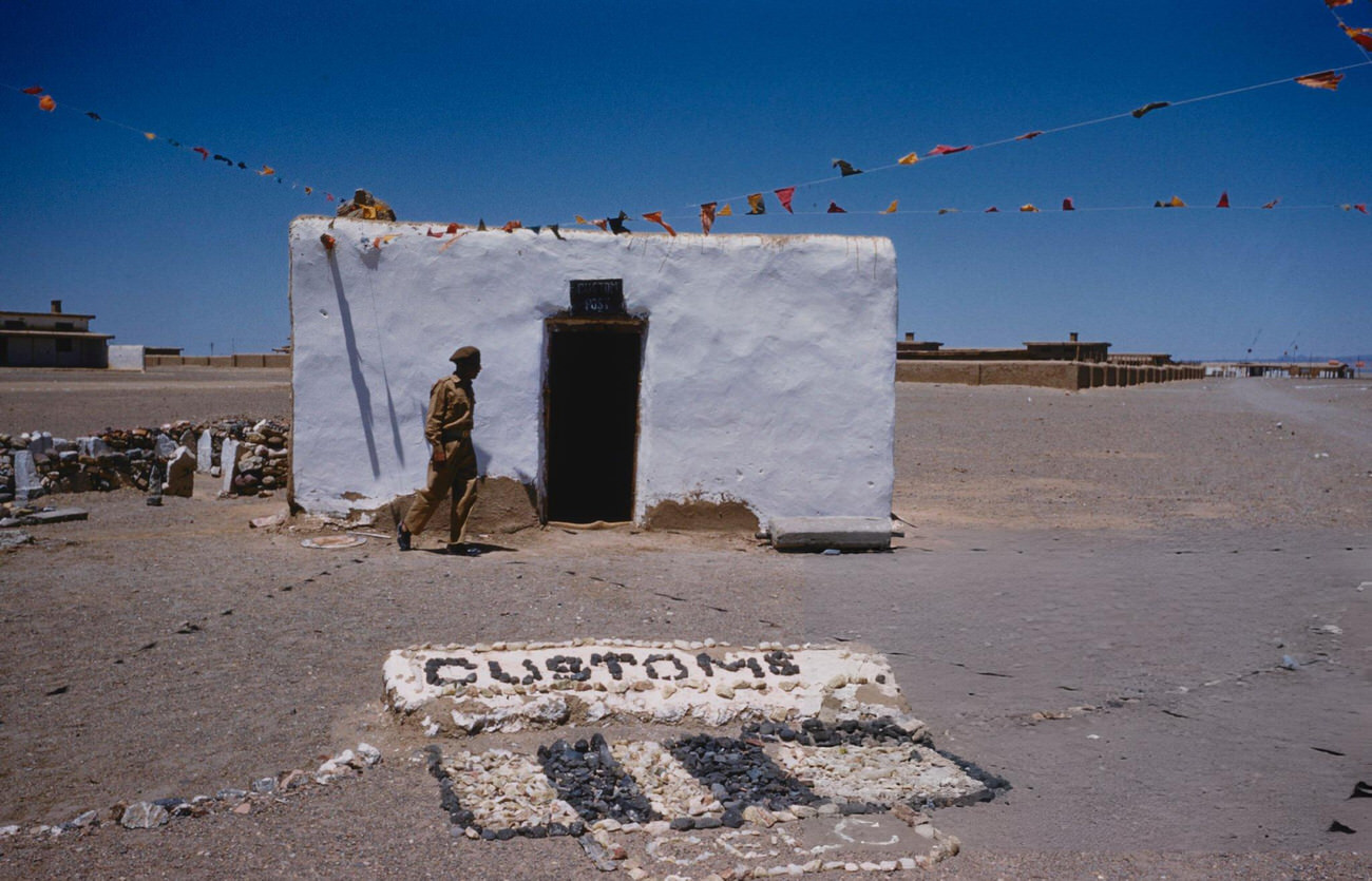 A security official walks past a customs post building in the desert town of Nok Kundi near the border with Iran in Balochistan, 1961.