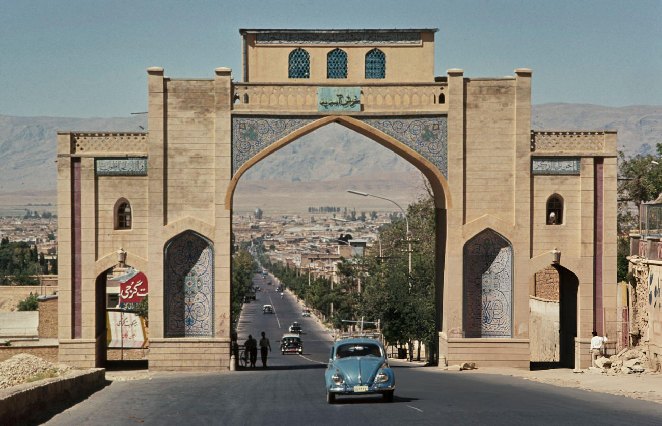 A Volkswagen Beetle car driving through the Qur'an Gate on the road from the northeast into Shiraz, in Fars Province, Iran, 1960s.