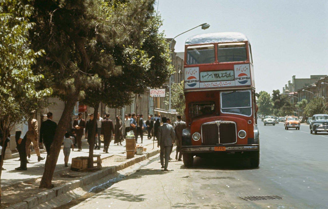 Pedestrians walking past an AEC Regent V double-decker bus at a bus stop on Ferdausi Street in Tehran, the capital of Iran, 1967.