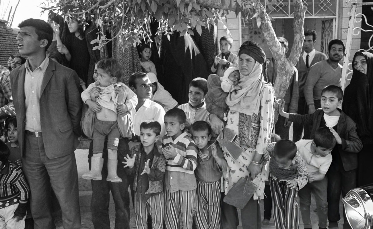 Iranian women and children on the route of the procession upon the arrival of the French President in Persepolis, Iran, 1968.