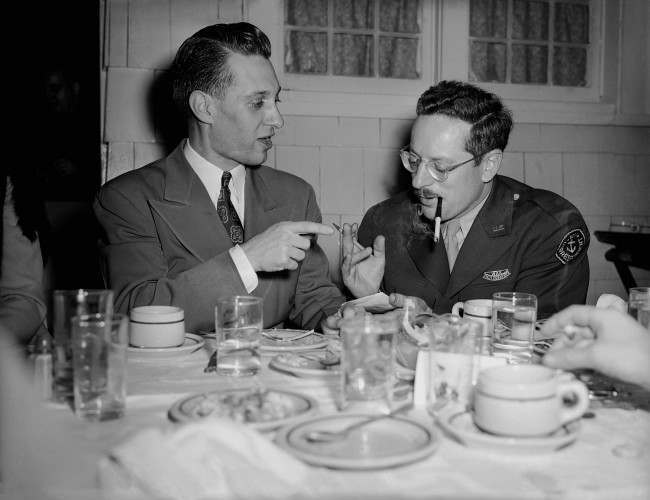 Associated Press photographer Joe Rosenthal, whose Iwo Jima Mount Suribachi flag-raising picture has made pictorial history, and Howard L. Kany, Washington news photo editor, enjoy a dinner in Joe’s honor, given during his visit to Washington by the AP Washington NewsPhoto staff, 1945.