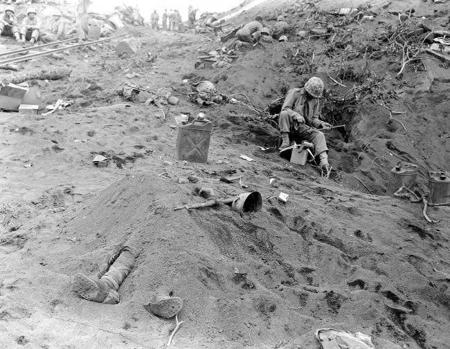 The booted feet of a dead Japanese soldier, protrude from beneath a mound of earth on Iwo Jima during the American invasion of the Japanese Volcano Island stronghold, 1945.