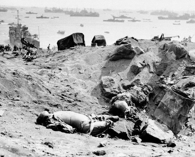 Two Japanese soldiers lay dead from the invasion armada seen in the background in Japan, 1945.