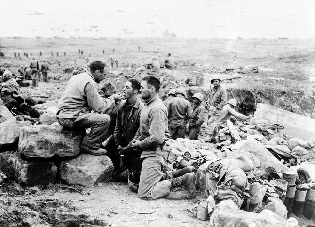 U.S. Marines receive communion from a Marine chaplain on Iwo Jima, the largest of the Japanese Volcano Islands, 1945.