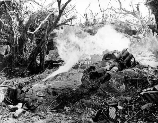 Two U.S. Marines directing flame throwers at Japanese defenses that block the way to Iwo Jima’s Mount Suribachi, 1945.