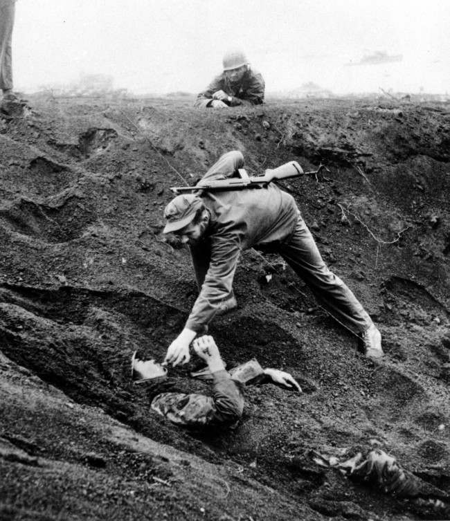 A U.S. Marine approaches a Japanese soldier on Iwo Jima, Japan, during World War II, 1945.