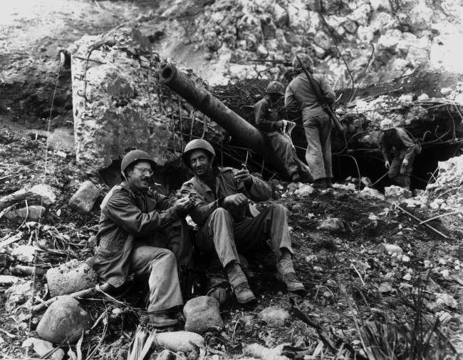 Joe Rosenthal, AP photographer, with Bob Campbell, a Marine, in front of a large Japanese gun, 1945.