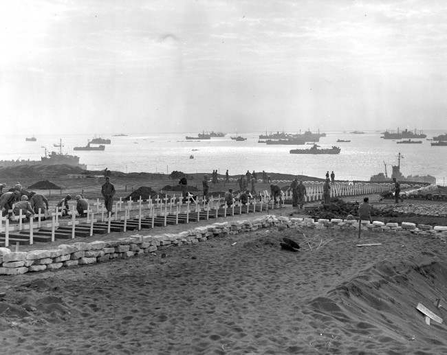 This is a photo of U.S. Marines preparing graves in the cemetery of the third and Fourth Marine Divisions for their buddies who died in taking the island of Iwo Jima, Japan, during World War II, 1945.