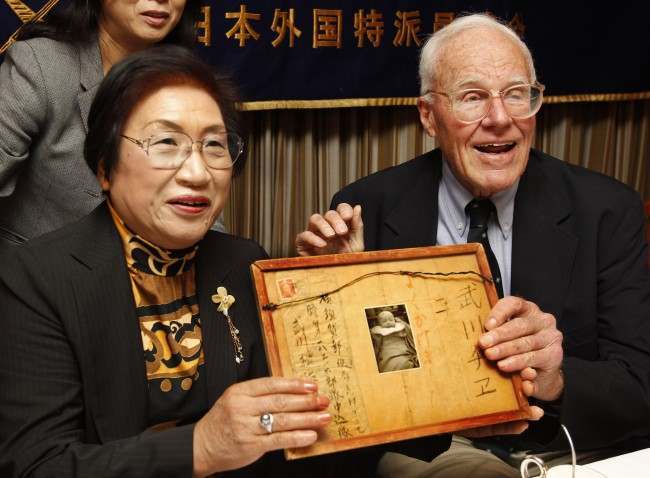 Former U.S. soldier fighting on Iwo Jima during the World War II, Franklin Hobbs, right, and Chie Takekawa, whose father was killed in the same battle, hold a framed letter and a photo of her sister during a press conference at the Foreign Correspondents Club of Japan in Tokyo, 2010.