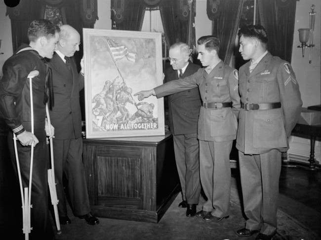 With the three survivors of the famed Mt. Suribachi flag-raising incident as his guests, President Truman gets the first of the new 7th war loan posters, based on Joe Rosenthal’s epic Iwo Jima photograph, at the White House, 1945.