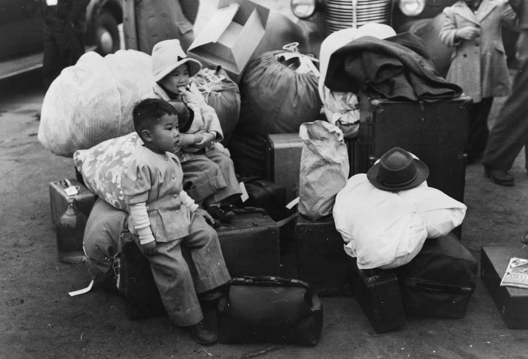 Japanese-Americans waiting for a train to take them and their parents to Owens Valley, 1942.