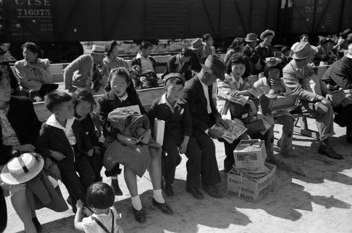 Japanese-Americans watching a train taking their friends and relatives to Owens Valley, Los Angeles, California, 1942.