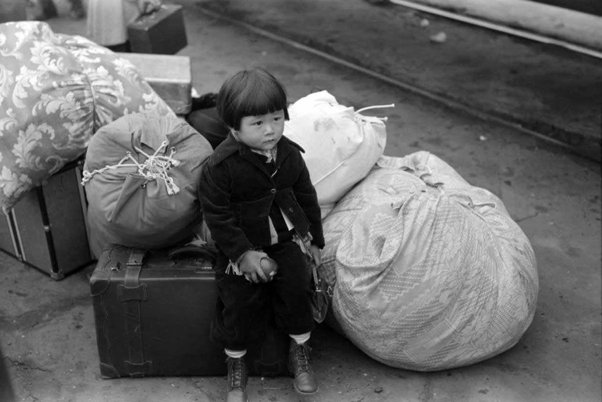 Los Angeles, California. Japanese-American child being evacuated with his parents to Owens Valley, 1942.