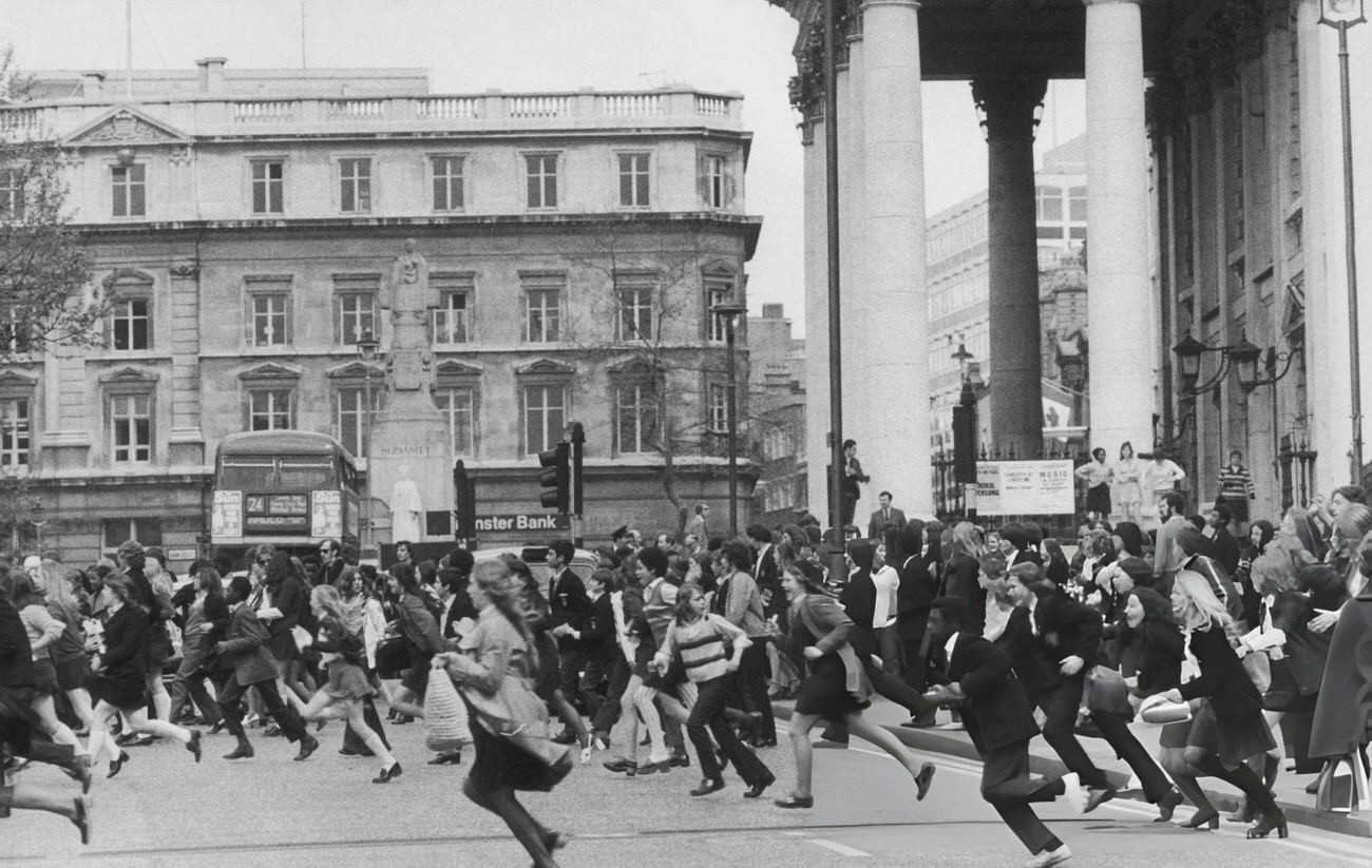 Pupils running across a road during a school strike demonstration, Trafalgar Square, London, 1972.