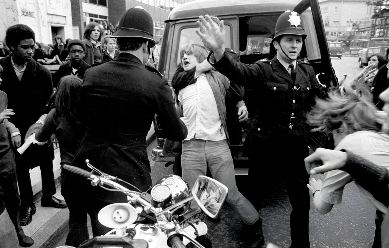 A policeman restrains a protestor outside County Hall in Lambeth, where schoolchildren were demonstrating in support of the demands put forward by the Schools Action Union, 1972.