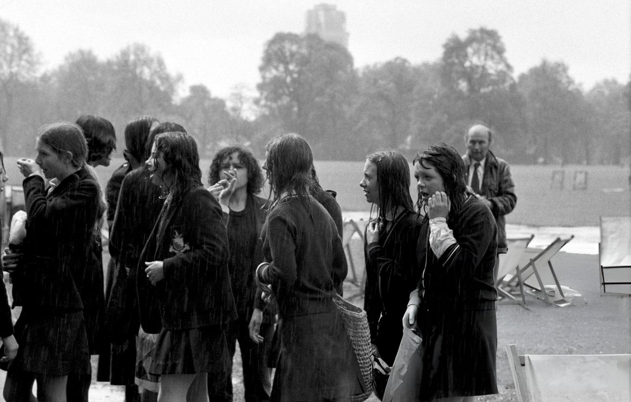 A group of schoolchildren head for shelter after a heavy downpour dampens their 'pupil power' demonstration at Speaker's Corner in Hyde Park, 1972.