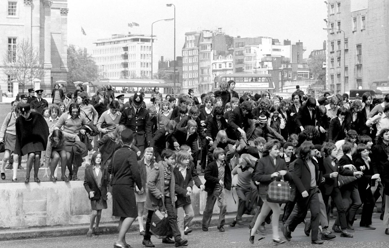 Schoolchildren clamber over the verges in Hyde Park, where a 'pupil power' demonstration took place at Speakers' Corner. They then marched to County Hall, 1972.