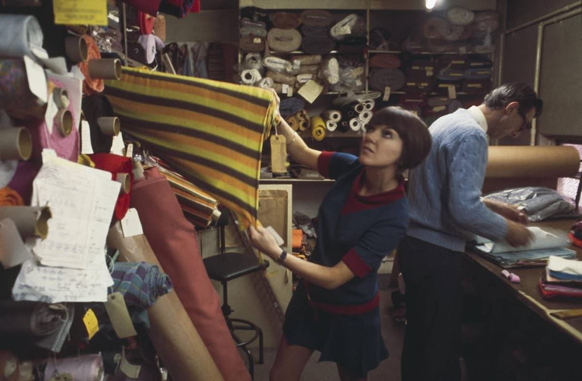 Mary Quant selects rolls of fabric from a warehouse store in London to create samples for a future collection in 1967