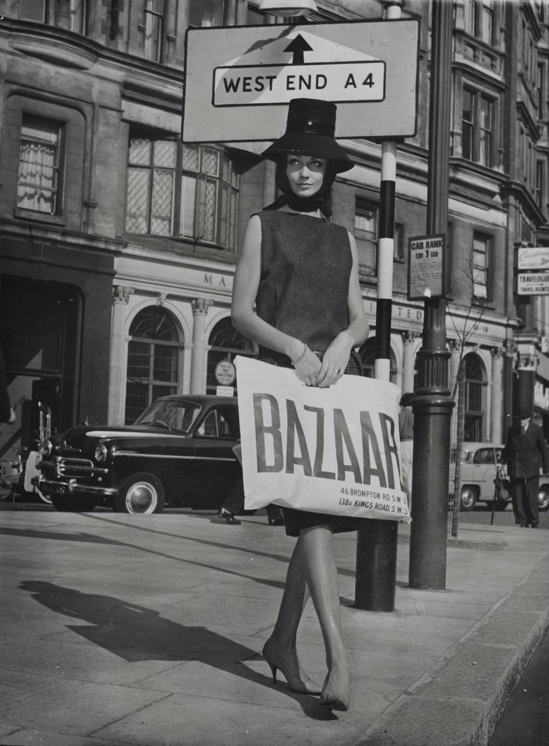 Model holding a Bazaar bag outside Bazaar and the Markham Arms on the King’s Road c.1959