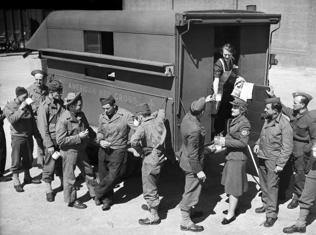 An American Red Cross mobile canteen on the quay of a Northern Ireland port furnishes hot coffee for some of the American soldiers who landed there with the largest A.E.F. of the current war, May 27, 1942. The uniformed Red Cross worker is Miss Louisa Farrand of New York City.