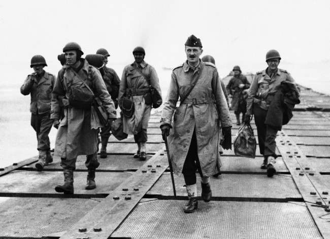 French General Philippe Le Clerc, carrying walking stick, shown walking down a pier somewhere in Normandy, France, 1944, after his arrival. This is his first visit to France in four years.