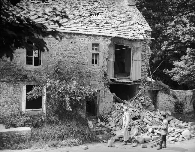 Two French civilians look over the wrecked birthplace of the French painter, Jean-Francois Millet in France, 1944. The house was situated at Gruchy near Greville, which was one of the most heavily fortified regions on the Normandy coast and the scene of many bitter battles before it was liberated by the Americans. Many Nazi soldiers were taken prisoner near here.