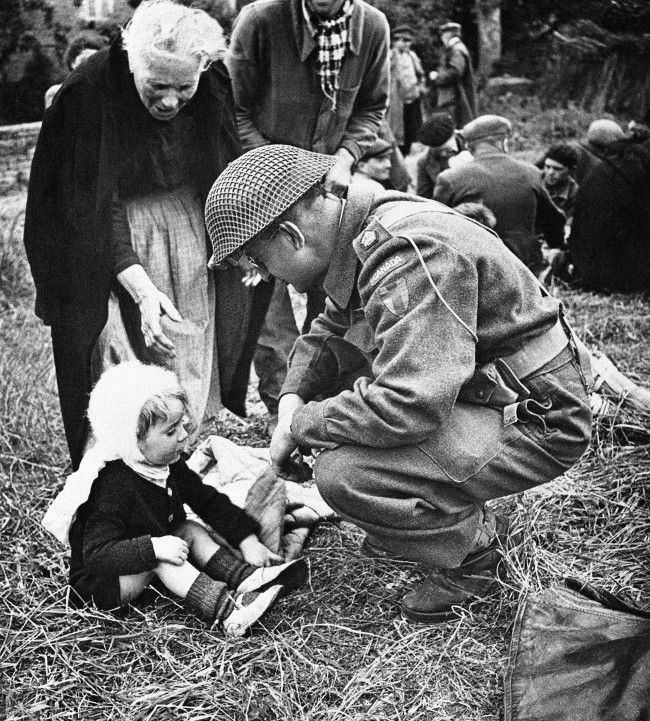 A Canadian soldier, serving with the British forces in Normandy, France, strikes up an acquaintance with a little French girl, 1944, one of a group of refugees that were fed by the liberating armies. The feeding arrangements were organized by the Civil Affairs.