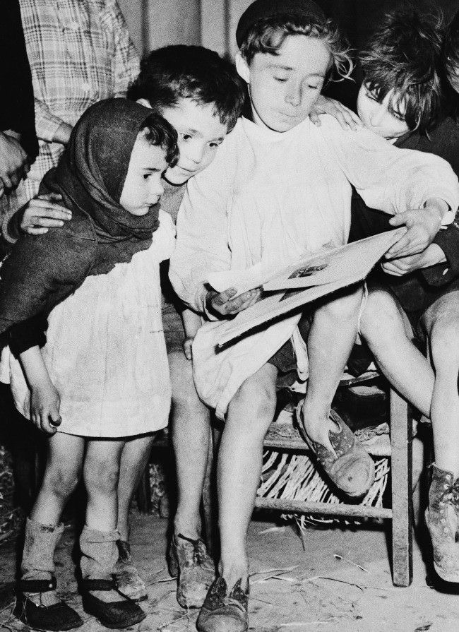 While the battle raged around them during the allied push in Normandy last summer, these French children found refuge in the Cathedral in Caen. Most of them were stocking less, their shoes were torn, their garments shoddy, 1945.