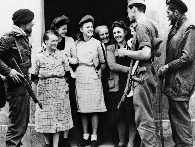 Villagers of Amfreville, France, chat with members of a French commando unit who landed in Normandy with Allied forces, 1944.