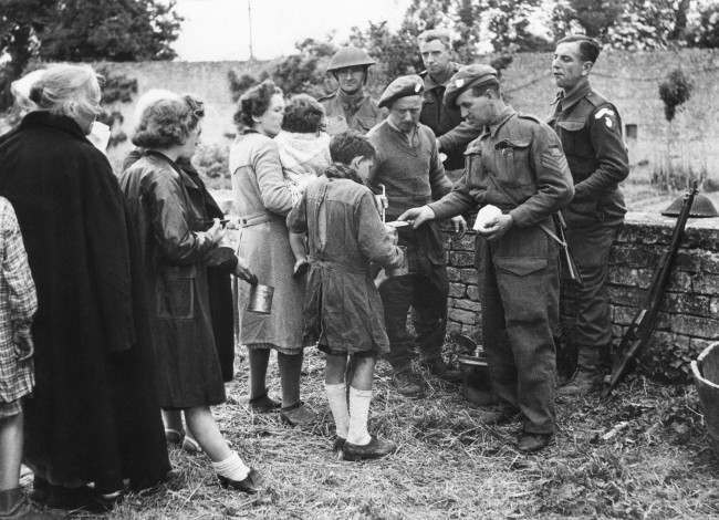 Many of the French refugees had not eaten for three or more days. They are seen receiving food from British troops in France, 1944.