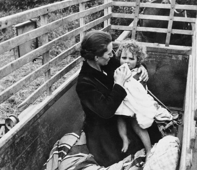 Arriving behind the allied lines in Normandy via the family horse-drawn wagon, a French mother and child take advantage of their first few moments of safety to spruce up a bit, 1944.