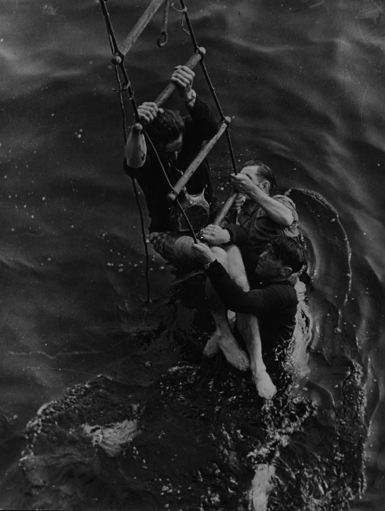 Operation Dynamo: Three men being rescued from the sea after having to abandon ship during their evacuation from the beaches at Dunkirk, 1940.