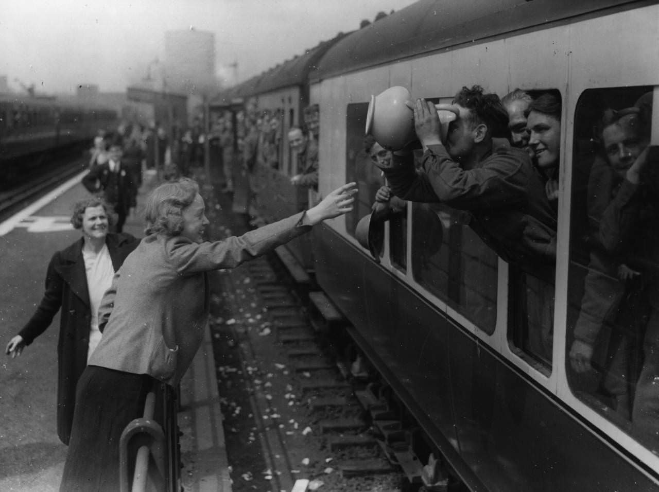 A long drink for a member of the BEF at the end of his journey home from Dunkirk, 1940.