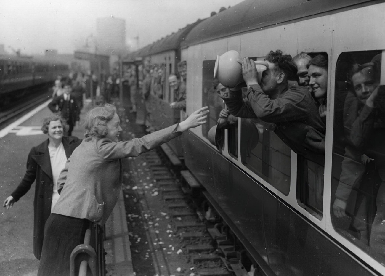 A long drink for a member of the BEF at the end of his journey home from Dunkirk, 1940.