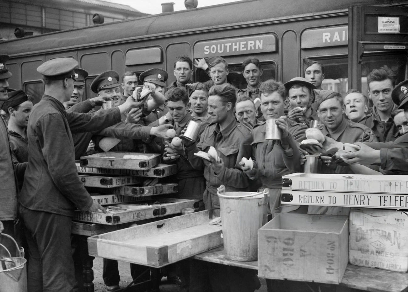 Evacuated troops enjoying tea and other refreshments at Addison Road station, London, 1940.